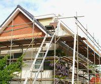 stock-photo-outside-renovation-of-a-modern-house-scaffolding-tower-393989602